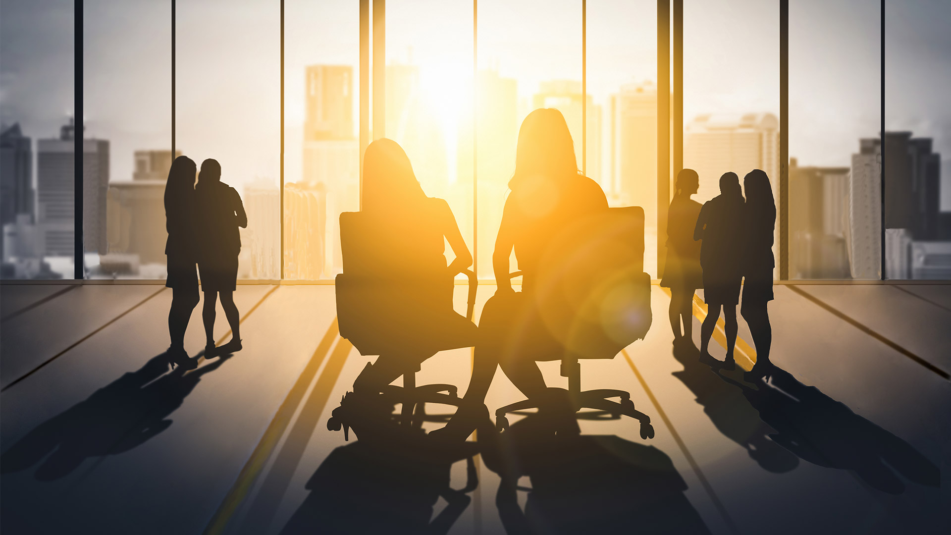 Women sitting and standing in a corporate setting